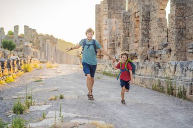 Baba ve oğul turistler Antalya Türkiye yakınlarındaki antik Perge şehrinin kalıntılarında. Çocuk konseptiyle seyahat etmek.