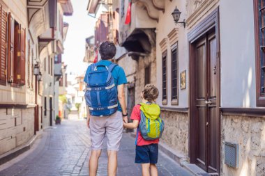 Antalya 'nın arka planında mutlu baba ve oğul turistler. Çocuk konseptiyle seyahat etmek. Erkek turist ilginç yerler ve popüler yerler keşfeder ve eski şehirde yürür.