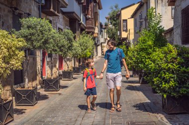Antalya 'nın arka planında mutlu baba ve oğul turistler. Çocuk konseptiyle seyahat etmek. Erkek turist ilginç yerler ve popüler yerler keşfeder ve eski şehirde yürür.