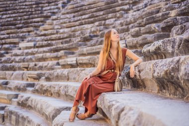 Kadın turist Aspendos Antik Şehri 'ni keşfediyor. Aspendos akropolis şehir kalıntıları, sarnıçlar, su kemerleri ve eski tapınaklar. Aspendos Antalya hindisi. Türkiye.