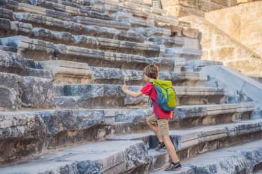 Çocuk turist Aspendos Antik Şehri 'ni keşfediyor. Çocuk konseptiyle seyahat etmek. Aspendos akropolis şehir kalıntıları, sarnıçlar, su kemerleri ve eski tapınaklar. Aspendos Antalya hindisi. Türkiye.