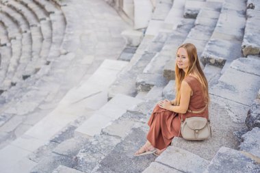Kadın turist Aspendos Antik Şehri 'ni keşfediyor. Aspendos akropolis şehir kalıntıları, sarnıçlar, su kemerleri ve eski tapınaklar. Aspendos Antalya hindisi. Türkiye.