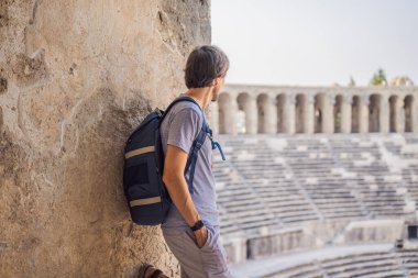 Erkek turist Aspendo Antik Şehir 'i keşfediyor. Aspendos akropolis şehir kalıntıları, sarnıçlar, su kemerleri ve eski tapınaklar. Aspendos Antalya hindisi. Türkiye.