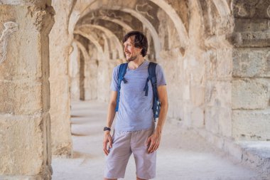 Erkek turist Aspendo Antik Şehir 'i keşfediyor. Aspendos akropolis şehir kalıntıları, sarnıçlar, su kemerleri ve eski tapınaklar. Aspendos Antalya hindisi. Türkiye.