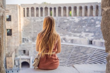 Kadın turist Aspendos Antik Şehri 'ni keşfediyor. Aspendos akropolis şehir kalıntıları, sarnıçlar, su kemerleri ve eski tapınaklar. Aspendos Antalya hindisi. Türkiye.