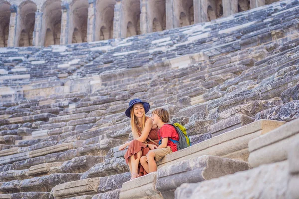 mother and son tourists explores Aspendos Ancient City. Traveling with kids concept. Aspendos acropolis city ruins, cisterns, aqueducts and old temple. Aspendos Antalya Turkey. turkiye.