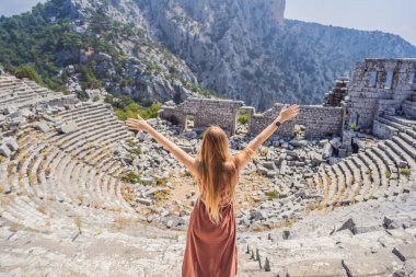 Kadın turist, Antik Termessos Şehrinin Çarpıcı Antik Tiyatrosunu keşfediyor. Hindi, her yere git.