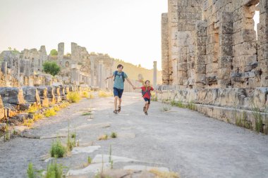 Baba ve oğul turistler Antalya Türkiye yakınlarındaki antik Perge şehrinin kalıntılarında. Çocuk konseptiyle seyahat etmek.