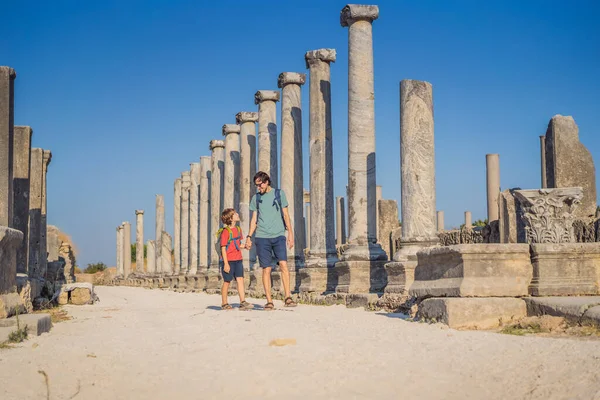 stock image dad and son tourists at the ruins of ancient city of Perge near Antalya Turkey. Traveling with kids concept.