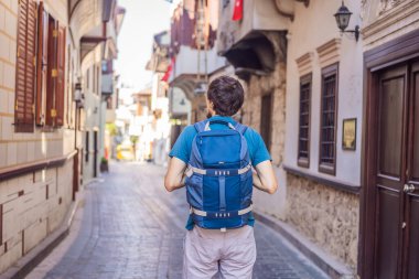 Antalya 'nın arka planındaki mutlu turist. Erkek turist ilginç yerler ve popüler yerler keşfediyor ve Türkiye 'nin Antalya kentindeki eski Kalechi kentinde yürüyor. Türkiye.