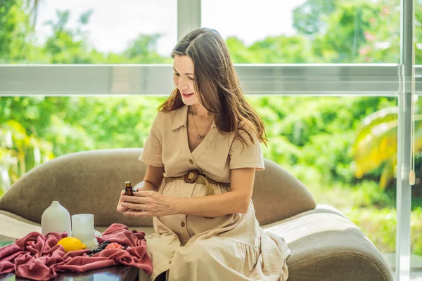 A serene moment captured as a pregnant woman after 40 embraces the soothing benefits of aroma oils and an aroma diffuser, enhancing her pregnancy journey with relaxation and tranquility.