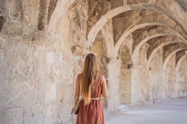 Kadın turist Aspendos Antik Şehri 'ni keşfediyor. Aspendos akropolis şehir kalıntıları, sarnıçlar, su kemerleri ve eski tapınaklar. Aspendos Antalya hindisi. Türkiye.