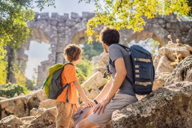 Baba ve oğul turistler Büyüleyici Antik Termessos Tiyatrosu 'nu keşfediyorlar. Çocuk konseptiyle seyahat etmek. Hindi, her yere git..