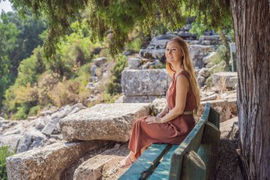 Kadın turist, Antik Termessos Şehrinin Çarpıcı Antik Tiyatrosunu keşfediyor. Hindi, her yere git.