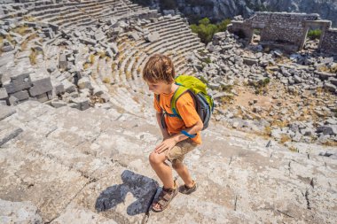 Çocuk Termessos Antik Şehir 'in Çarpıcı Antik Tiyatrosu' nu keşfediyor. Çocuk konseptiyle seyahat etmek. Hindi, her yere git..