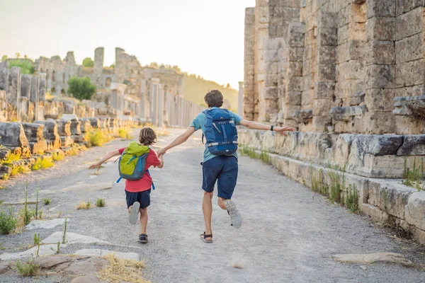 Baba ve oğul turistler Antalya Türkiye yakınlarındaki antik Perge şehrinin kalıntılarında. Çocuk konseptiyle seyahat etmek.