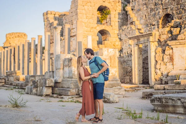 Loving couple of tourists at the ruins of ancient city of Perge near Antalya Turkey. Traveling with kids concept.
