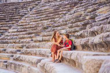 Anne ve oğul turistler Aspendo Antik Şehri 'ni keşfediyorlar. Çocuk konseptiyle seyahat etmek. Aspendos akropolis şehir kalıntıları, sarnıçlar, su kemerleri ve eski tapınaklar. Aspendos Antalya hindisi. Türkiye.