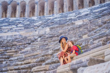 Anne ve oğul turistler Aspendo Antik Şehri 'ni keşfediyorlar. Çocuk konseptiyle seyahat etmek. Aspendos akropolis şehir kalıntıları, sarnıçlar, su kemerleri ve eski tapınaklar. Aspendos Antalya hindisi. Türkiye.