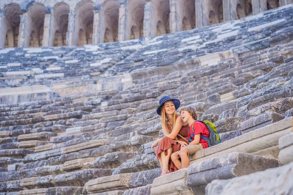 mother and son tourists explores Aspendos Ancient City. Traveling with kids concept. Aspendos acropolis city ruins, cisterns, aqueducts and old temple. Aspendos Antalya Turkey. turkiye.