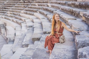 Kadın turist Aspendos Antik Şehri 'ni keşfediyor. Aspendos akropolis şehir kalıntıları, sarnıçlar, su kemerleri ve eski tapınaklar. Aspendos Antalya hindisi. Türkiye.