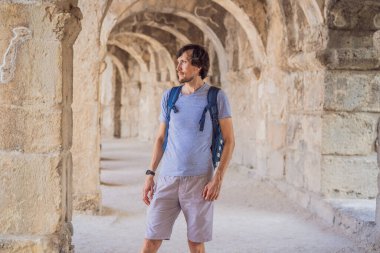 Erkek turist Aspendo Antik Şehir 'i keşfediyor. Aspendos akropolis şehir kalıntıları, sarnıçlar, su kemerleri ve eski tapınaklar. Aspendos Antalya hindisi. Türkiye.
