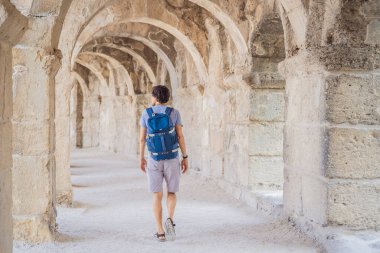 Erkek turist Aspendo Antik Şehir 'i keşfediyor. Aspendos akropolis şehir kalıntıları, sarnıçlar, su kemerleri ve eski tapınaklar. Aspendos Antalya hindisi. Türkiye.