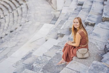 Kadın turist Aspendos Antik Şehri 'ni keşfediyor. Aspendos akropolis şehir kalıntıları, sarnıçlar, su kemerleri ve eski tapınaklar. Aspendos Antalya hindisi. Türkiye.