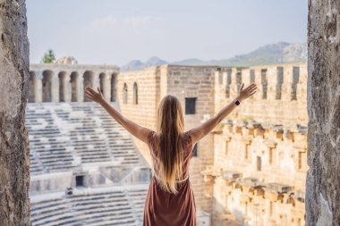 Kadın turist Aspendos Antik Şehri 'ni keşfediyor. Aspendos akropolis şehir kalıntıları, sarnıçlar, su kemerleri ve eski tapınaklar. Aspendos Antalya hindisi. Türkiye.