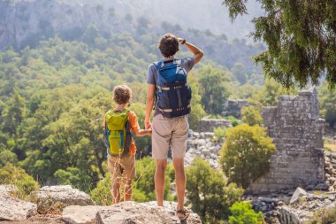 Baba ve oğul turistler Büyüleyici Antik Termessos Tiyatrosu 'nu keşfediyorlar. Çocuk konseptiyle seyahat etmek. Hindi, her yere git..