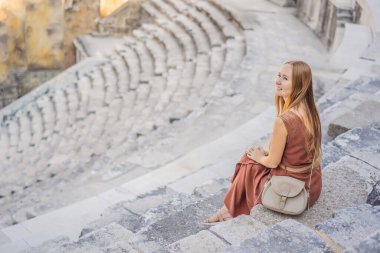 Kadın turist Aspendos Antik Şehri 'ni keşfediyor. Aspendos akropolis şehir kalıntıları, sarnıçlar, su kemerleri ve eski tapınaklar. Aspendos Antalya hindisi. Türkiye.