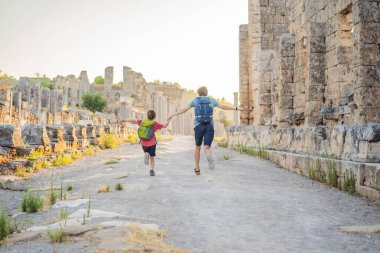 Baba ve oğul turistler Antalya Türkiye yakınlarındaki antik Perge şehrinin kalıntılarında. Çocuk konseptiyle seyahat etmek.