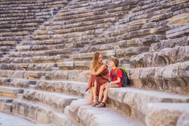 Anne ve oğul turistler Aspendo Antik Şehri 'ni keşfediyorlar. Çocuk konseptiyle seyahat etmek. Aspendos akropolis şehir kalıntıları, sarnıçlar, su kemerleri ve eski tapınaklar. Aspendos Antalya hindisi. Türkiye.
