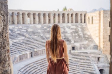 Kadın turist Aspendos Antik Şehri 'ni keşfediyor. Aspendos akropolis şehir kalıntıları, sarnıçlar, su kemerleri ve eski tapınaklar. Aspendos Antalya hindisi. Türkiye.