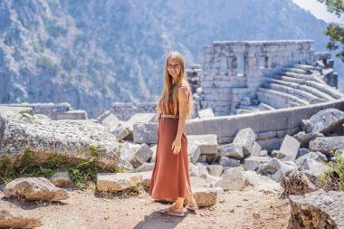 Kadın turist, Antik Termessos Şehrinin Çarpıcı Antik Tiyatrosunu keşfediyor. Hindi, her yere git.