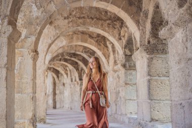 Kadın turist Aspendos Antik Şehri 'ni keşfediyor. Aspendos akropolis şehir kalıntıları, sarnıçlar, su kemerleri ve eski tapınaklar. Aspendos Antalya hindisi. Türkiye.