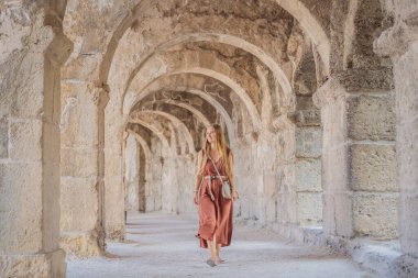 Kadın turist Aspendos Antik Şehri 'ni keşfediyor. Aspendos akropolis şehir kalıntıları, sarnıçlar, su kemerleri ve eski tapınaklar. Aspendos Antalya hindisi. Türkiye.
