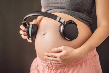 Rahimdeki melodiler: hamile bir karnına yerleştirilmiş kulaklıklar, müzikle bağlanma, anne ve bebek arasında yürek ısıtan bir bağ.