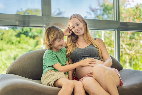 Heartwarming Moment Pregnant Mother Her Older Son Sit Sofa Engaging — Stock Photo, Image