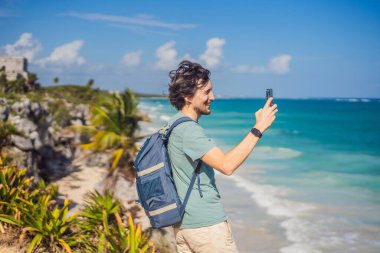 Erkek turist, Kolombiya öncesi Maya şehri Tulum, Quintana Roo, Meksika, Kuzey Amerika, Tulum, Meksika 'nın manzarasını seyrediyor. El Castillo - Şato Maya şehri Tulum ana tapınağı.