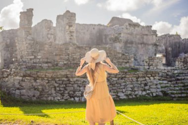 Kolombiya öncesi Maya şehri Tulum, Quintana Roo, Meksika, Kuzey Amerika, Tulum, Meksika manzarasının tadını çıkaran bir kadın turist. El Castillo - Şato Maya şehri Tulum ana tapınağı.