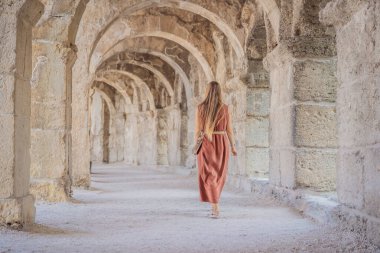 Kadın turist Aspendos Antik Şehri 'ni keşfediyor. Aspendos akropolis şehir kalıntıları, sarnıçlar, su kemerleri ve eski tapınaklar. Aspendos Antalya hindisi. Türkiye.