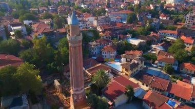 Gökyüzü stok videosu, ikonik Yivli Minare Camii Antalyas tarihi merkezi Türkiye 'nin göbeğinde yer alıyor. Kamera zarif bir şekilde yukarıda süzülüyor, bunun panoramik bir görüntüsünü sunuyor.