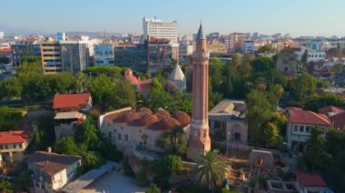 Gökyüzü stok videosu, ikonik Yivli Minare Camii Antalyas tarihi merkezi Türkiye 'nin göbeğinde yer alıyor. Kamera zarif bir şekilde yukarıda süzülüyor, bunun panoramik bir görüntüsünü sunuyor.