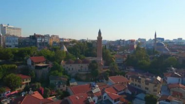 Gökyüzü stok videosu, ikonik Yivli Minare Camii Antalyas tarihi merkezi Türkiye 'nin göbeğinde yer alıyor. Kamera zarif bir şekilde yukarıda süzülüyor, bunun panoramik bir görüntüsünü sunuyor.