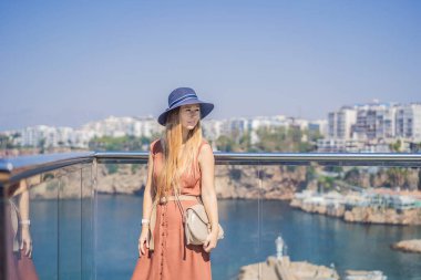 Antalya 'nın arka planındaki mutlu kadın turist. Kadın turist ilginç yerler ve popüler yerler keşfediyor ve Türkiye 'nin Antalya kentindeki eski Kalechi kentinde yürüyor. Türkiye.