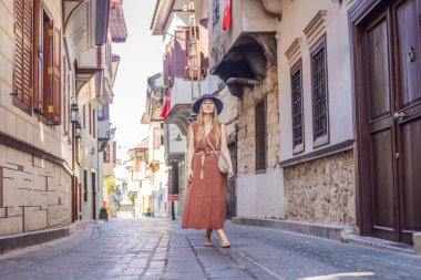 Antalya 'nın arka planındaki mutlu kadın turist. Kadın turist ilginç yerler ve popüler yerler keşfediyor ve Türkiye 'nin Antalya kentindeki eski Kalechi kentinde yürüyor. Türkiye.