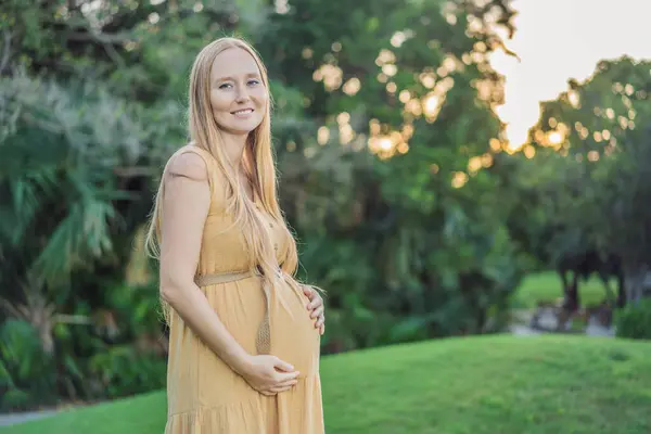 公園を歩いて幸せな妊娠中の女性 — ストック写真
