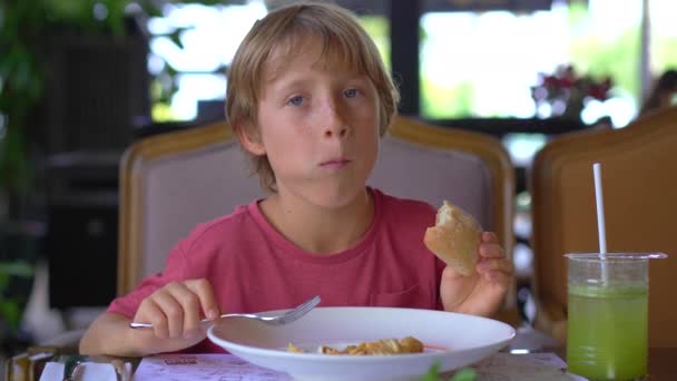 Rapazinho Está Comer Num Café Ele Está Comendo Bolinhos Fritos — Vídeo de Stock