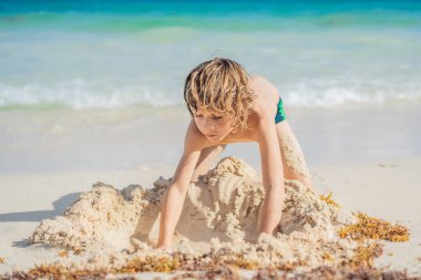 Genç oğlanlar kumsalın kumlu oyun alanını keşfederken saf zevk alırlar, kum tanecikleriyle rüyaları şekillendirirler..